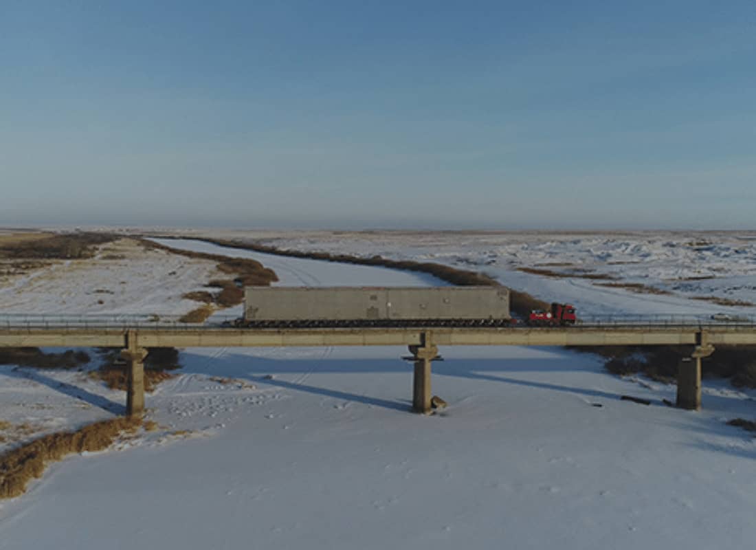 heavy cargo over a frozen river bridge.jpg